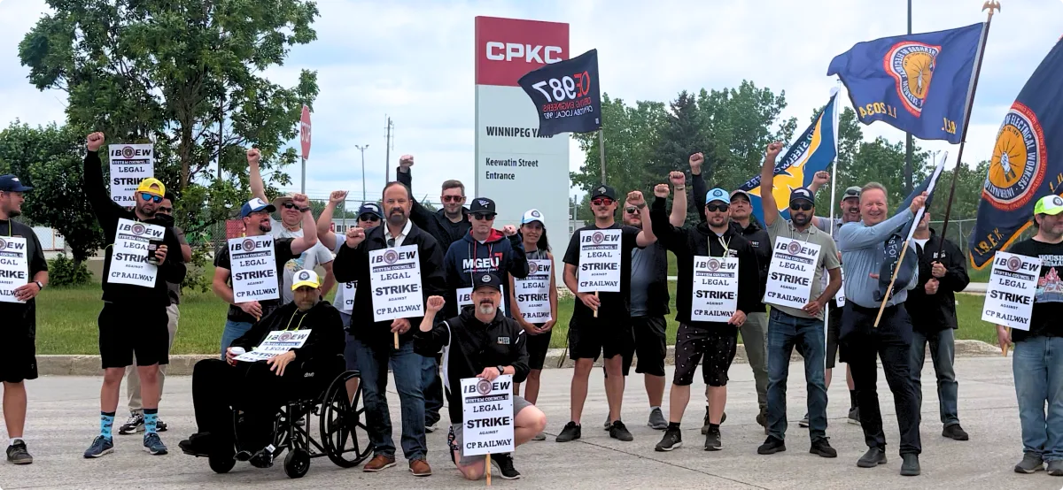 Workers represented by the International Brotherhood of Electrical Workers System Council 11 on the picket line.