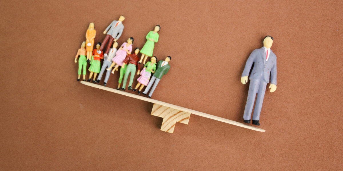 An imbalanced seesaw where one side is held down by one large business man, and the other side has many smaller businesses.