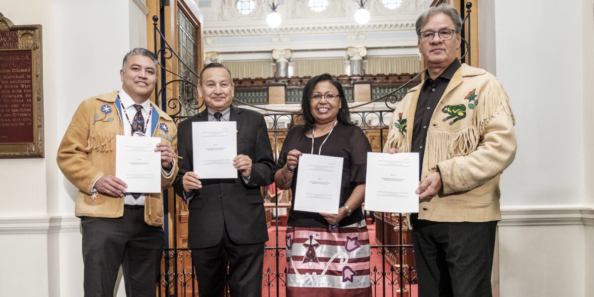 First Nations Leadership Council representatives hold up printed copies of the UN Declaration bill tabled in B.C. on Oct 24, 2019.