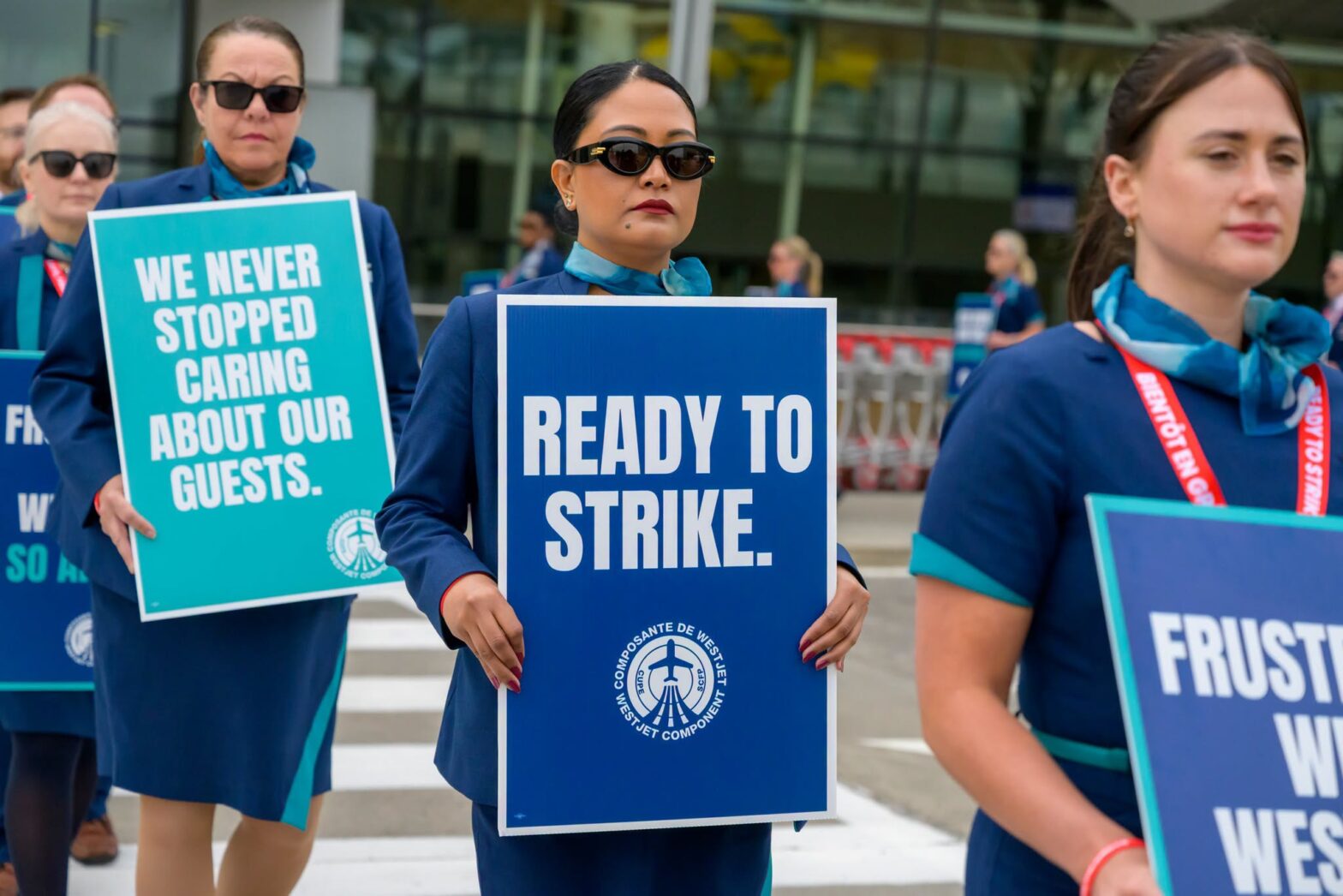 An image of a Westjet flight attendant, represented by CUPE 8125, holding a sign that says, "Ready to strike."