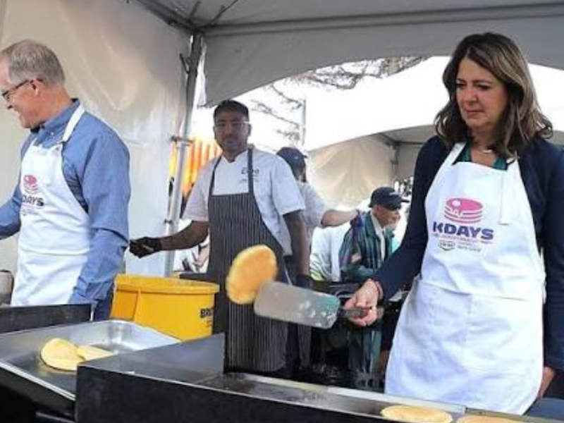 Alberta Premier Danielle Smith concentrates on flipping a pancake at the Premier’s K-Days Breakfast last Thursday as Environment Minister Grant Hunter entertains himself nearby.
