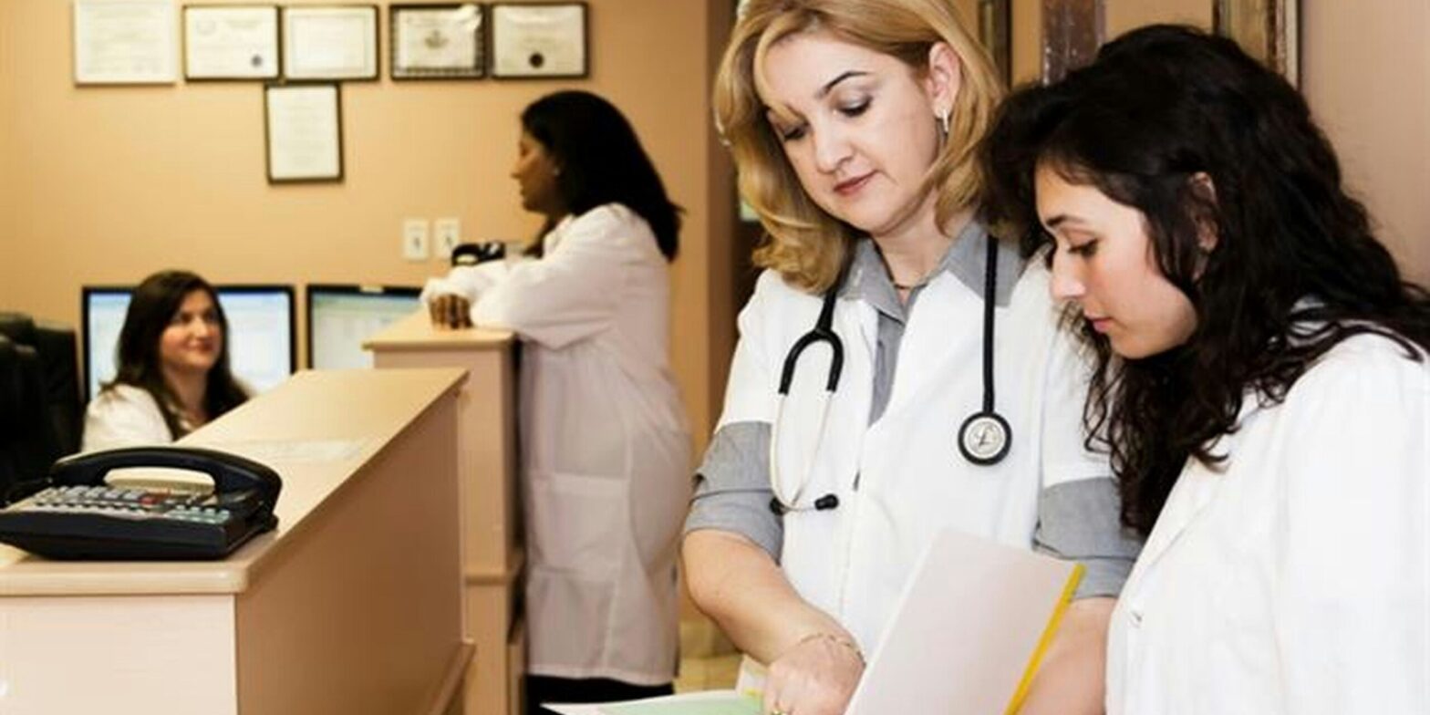 An image of a doctor and patient discussing the contents of a sheet of paper. The Abortion Rights Coalition of Canada is sharing their provincial referral sheets.